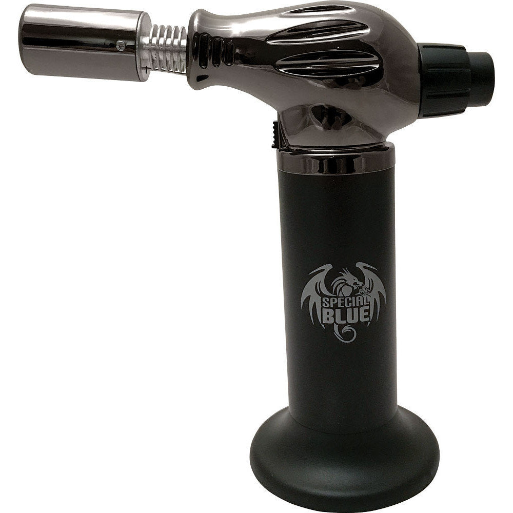 WEST COAST SPECIAL BLUE DUAL-FLAME TORCH - FLAME THROWER  The Special Blue Flame Thrower torch lighter stands 7.25″ tall and features a built-in base, auto ignition, and adjustable flame. This model works at any angle, refills quickly, is cordless and lightweight, and has a lifetime warranty from Special Blue that your customers will appreciate.